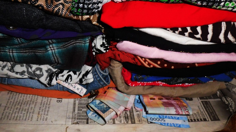Menyimpan uang di lipatan baju