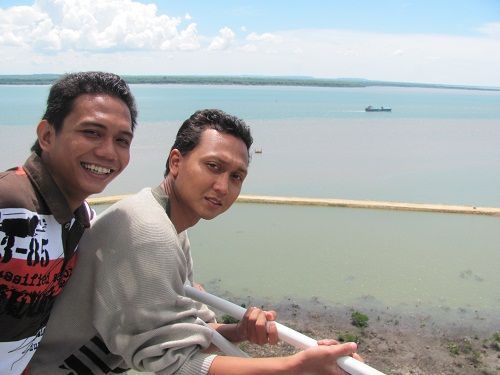 Mercusuar dengan pemandangan perairan dan langit yang biru.