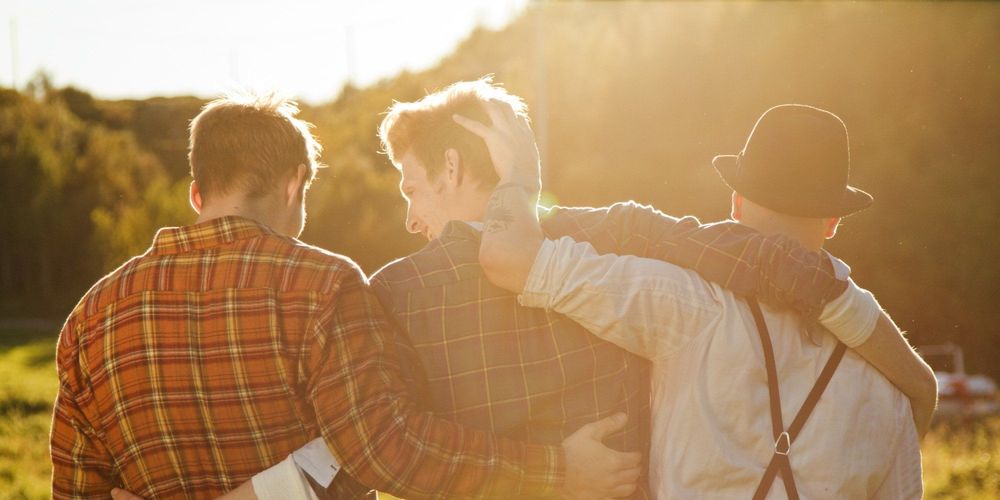 Three young men walking together on a field