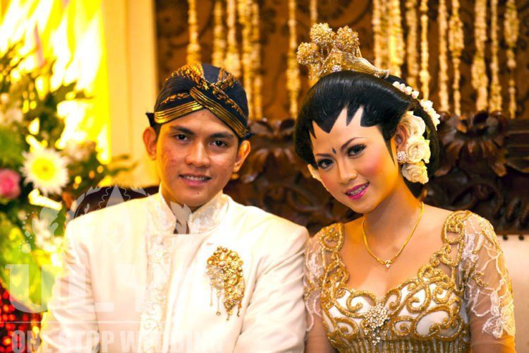 Riasan Jogja putri dengan tiga cundhuk, bunga yang diselipkan di samping konde, dan blangkon untuk si pria