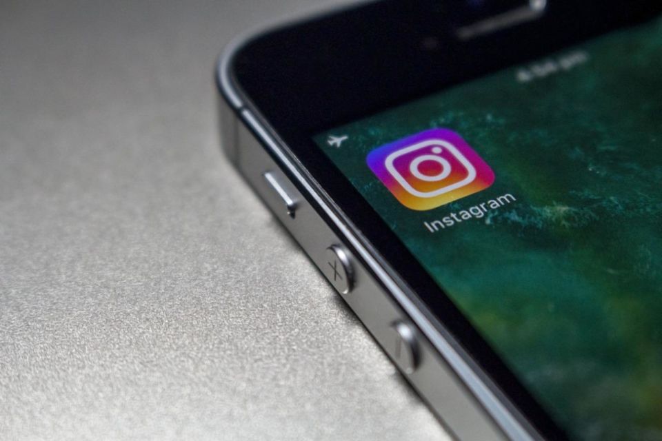 Foto orang yang memegang iphone menampilkan folder jaringan sosial oleh Oleg Magni dari Pexels