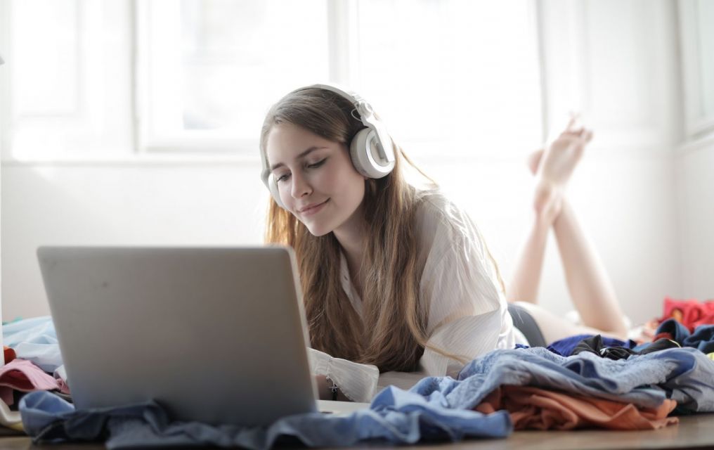 Mujeres con auriculares y portátiles.